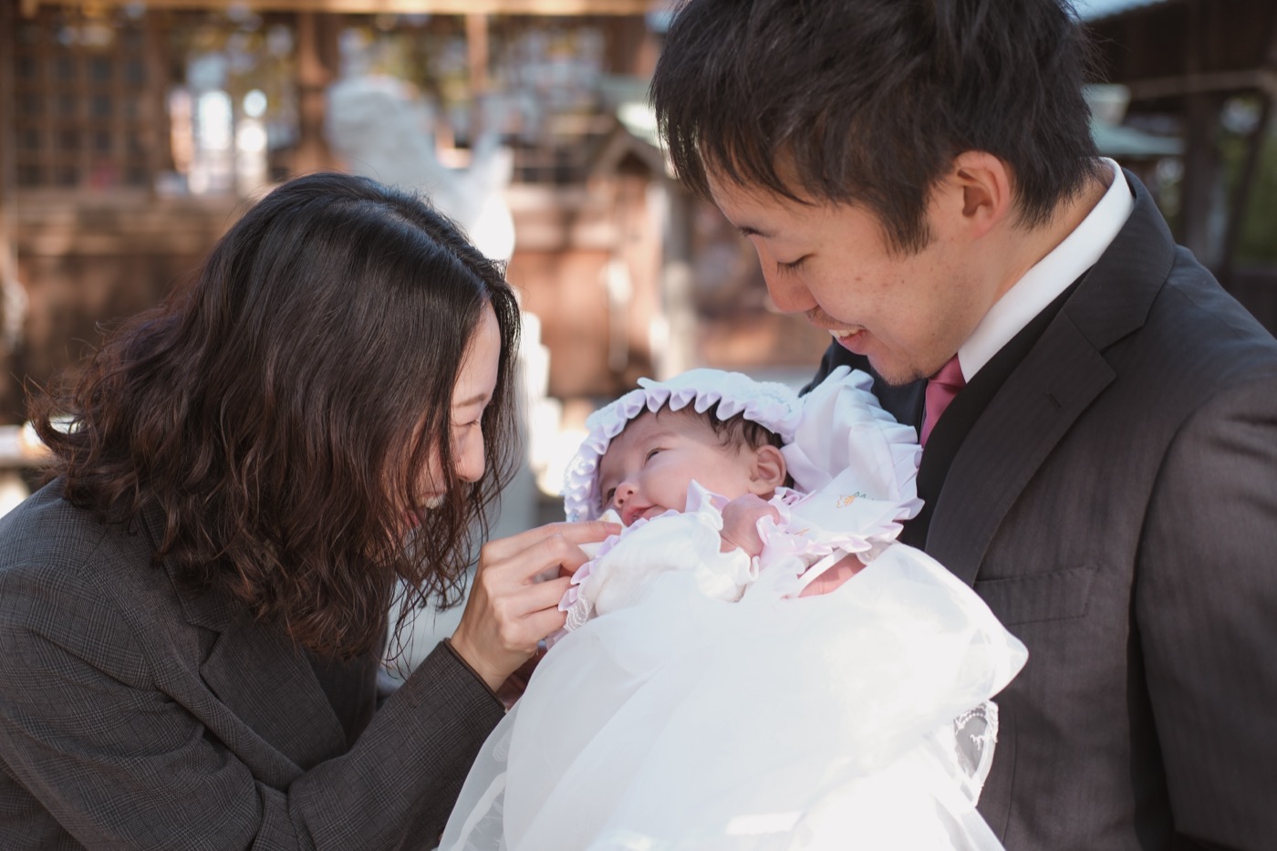 赤ちゃんを見つめる両親・お宮参り